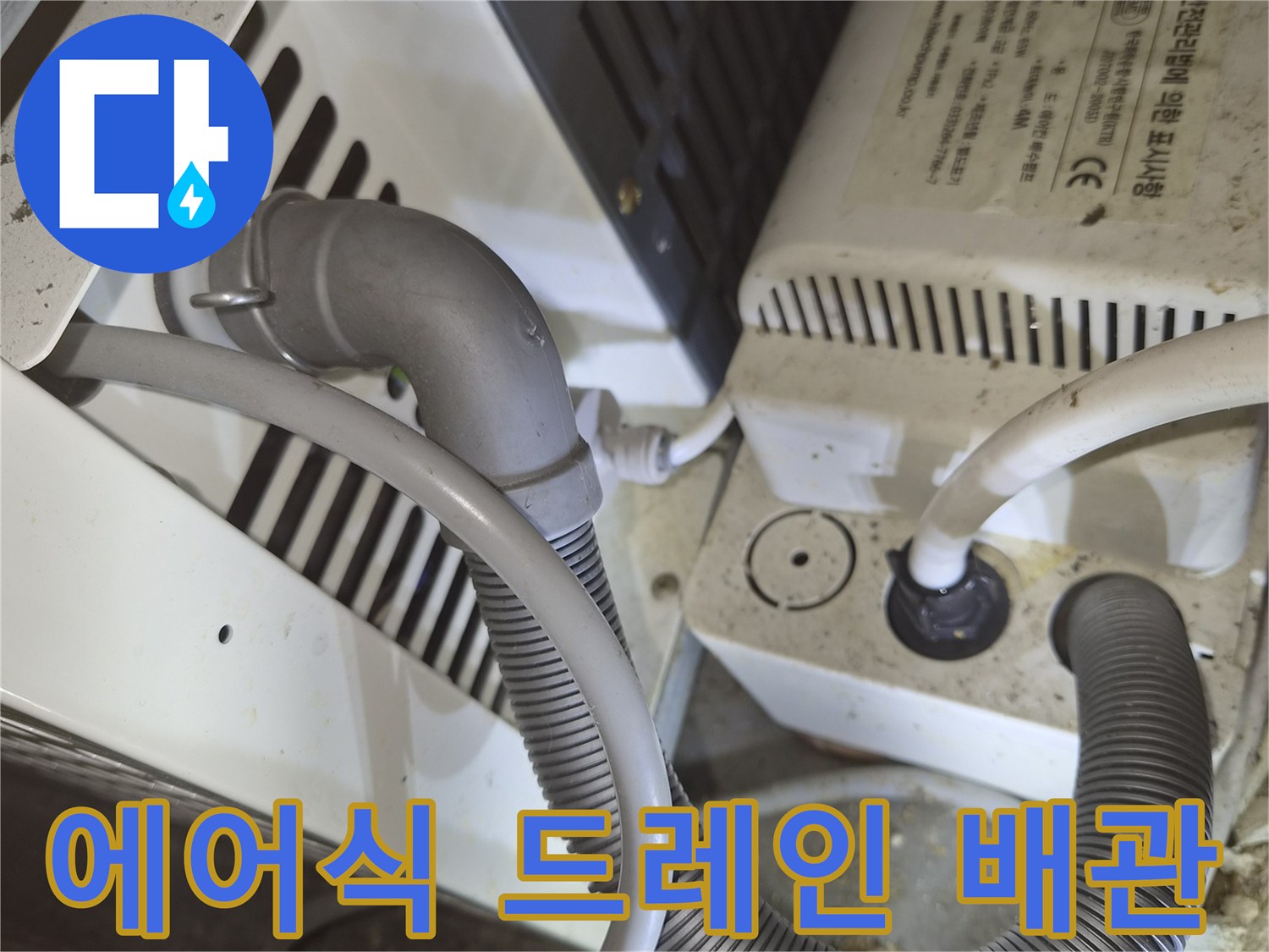 흰색 기계 장치와 연결된 회색 주름관의 모습