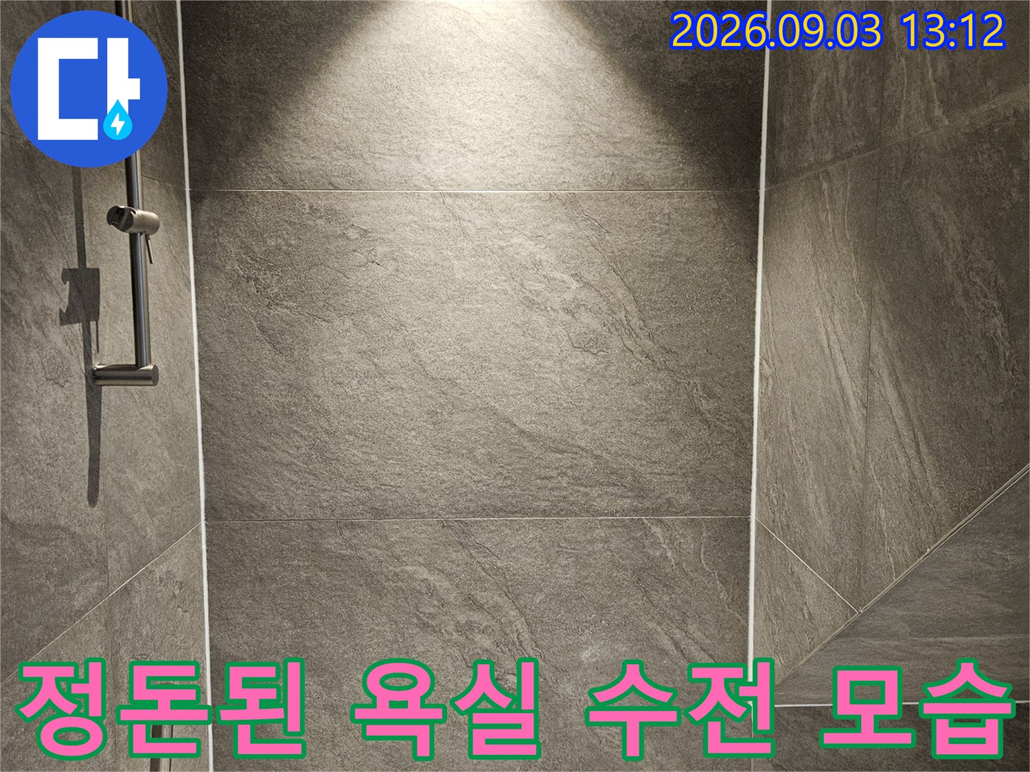 깔끔하게 설치된-욕실 수전과 회색 타일 벽면 이미지입니다