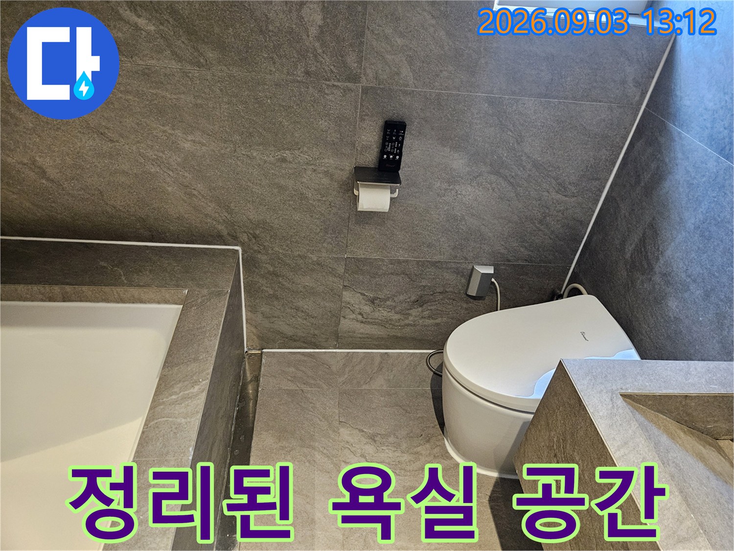 회색 타일로 깔끔하게 시공된 화장실 내부 전경입니다.