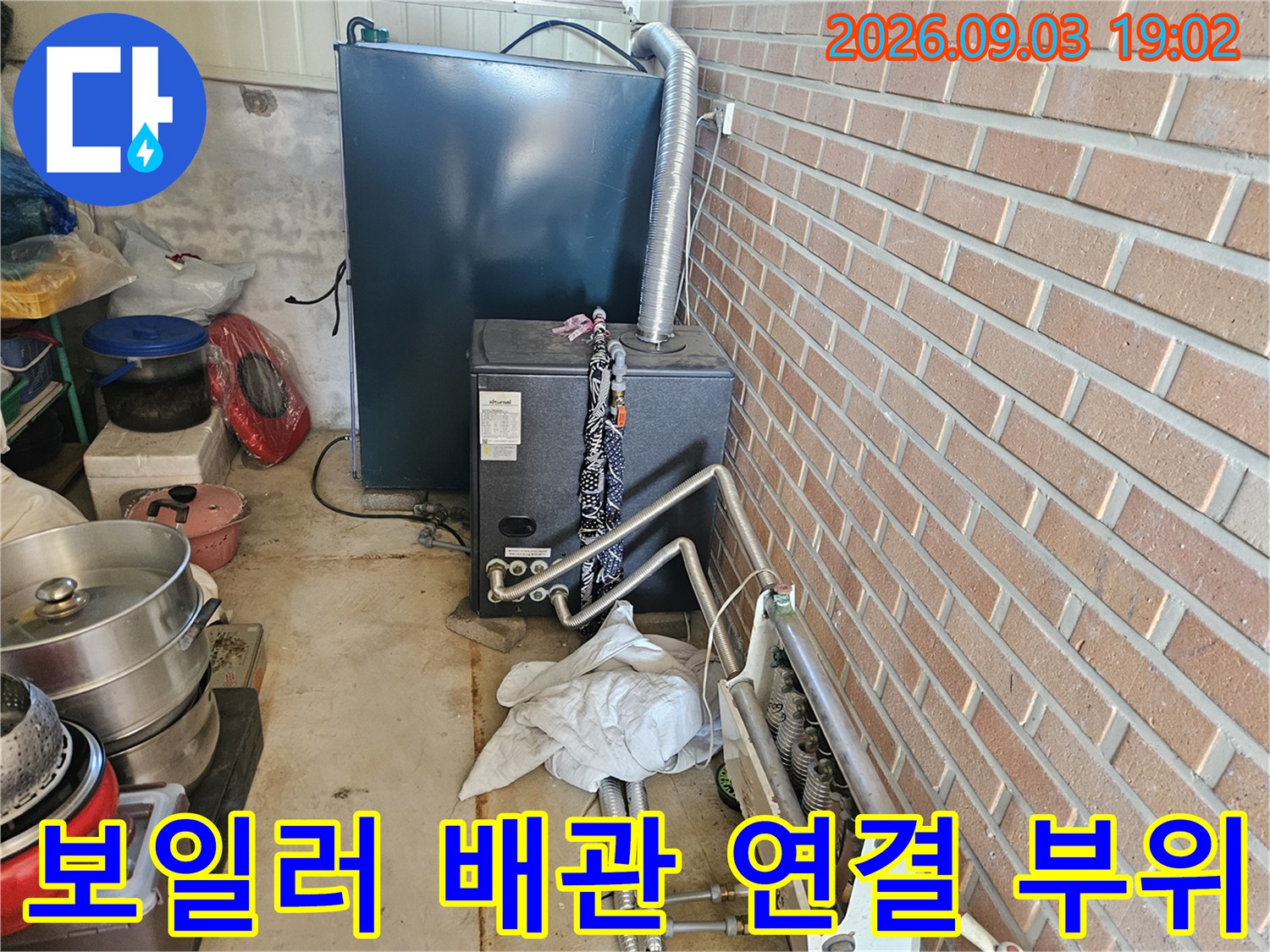 보일러 하단에 위치한 금속 배관과 연결 부속 상세 모습