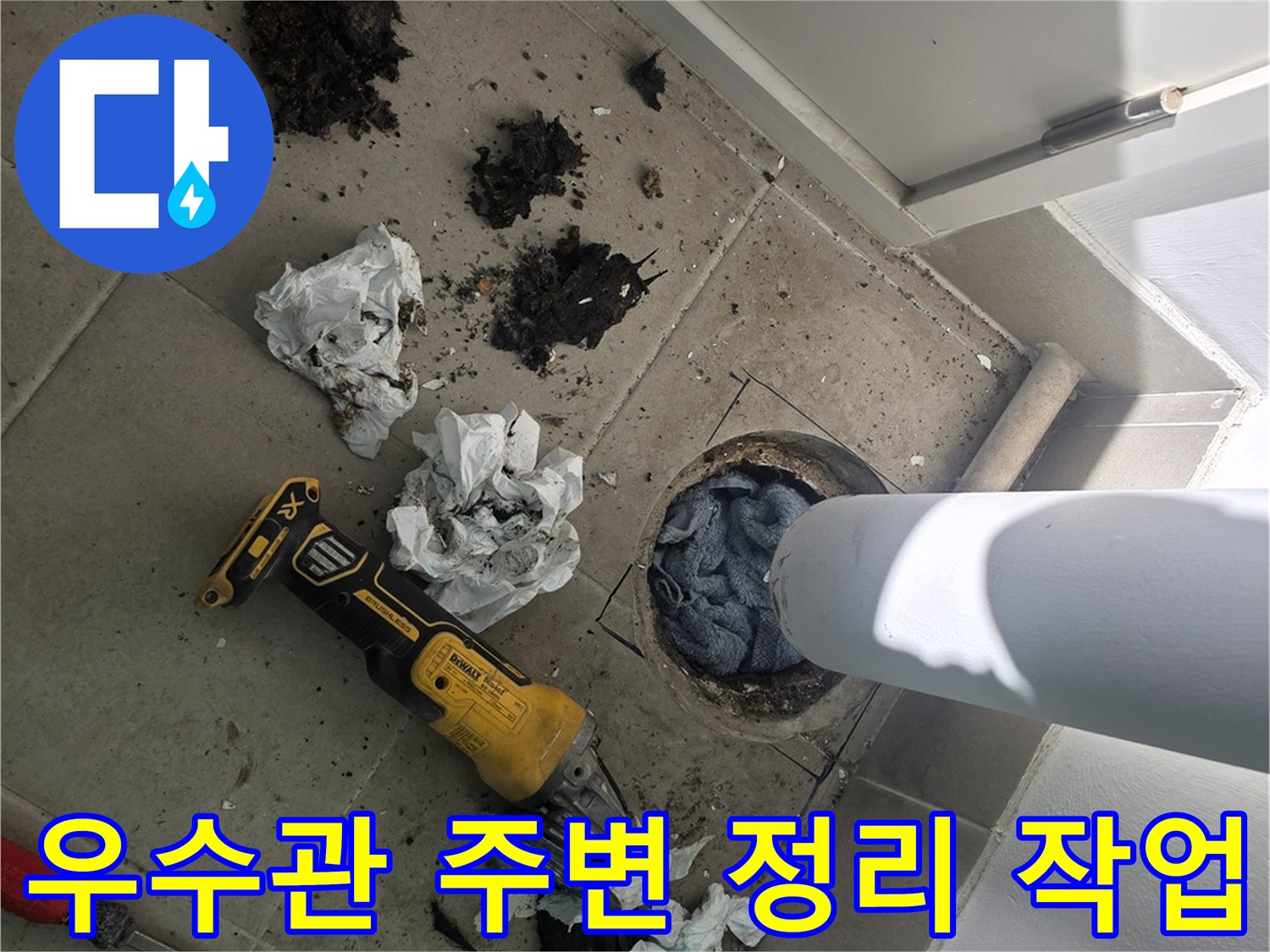 전동 공구를 사용하여 우수관 하단부의 오염물을 제거하는 현장 사진