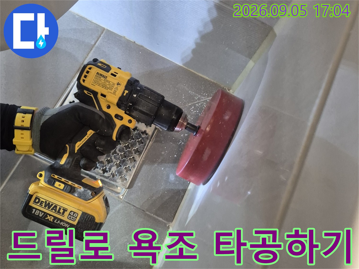 전동 드릴을 사용하여 욕조 옆면에 점검구를 내는 작업입니다.