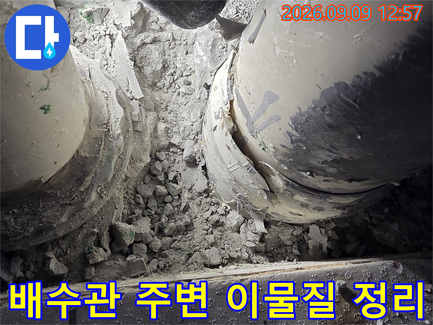 배수관 연결부의 파손된 마감재와 시멘트 가루