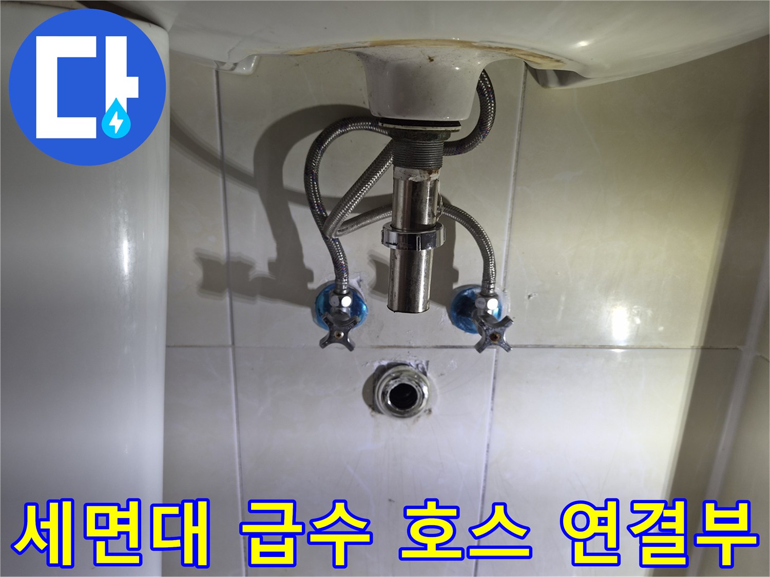 세면대 하단 은색 호스와 파란색 손잡이 밸브 부근