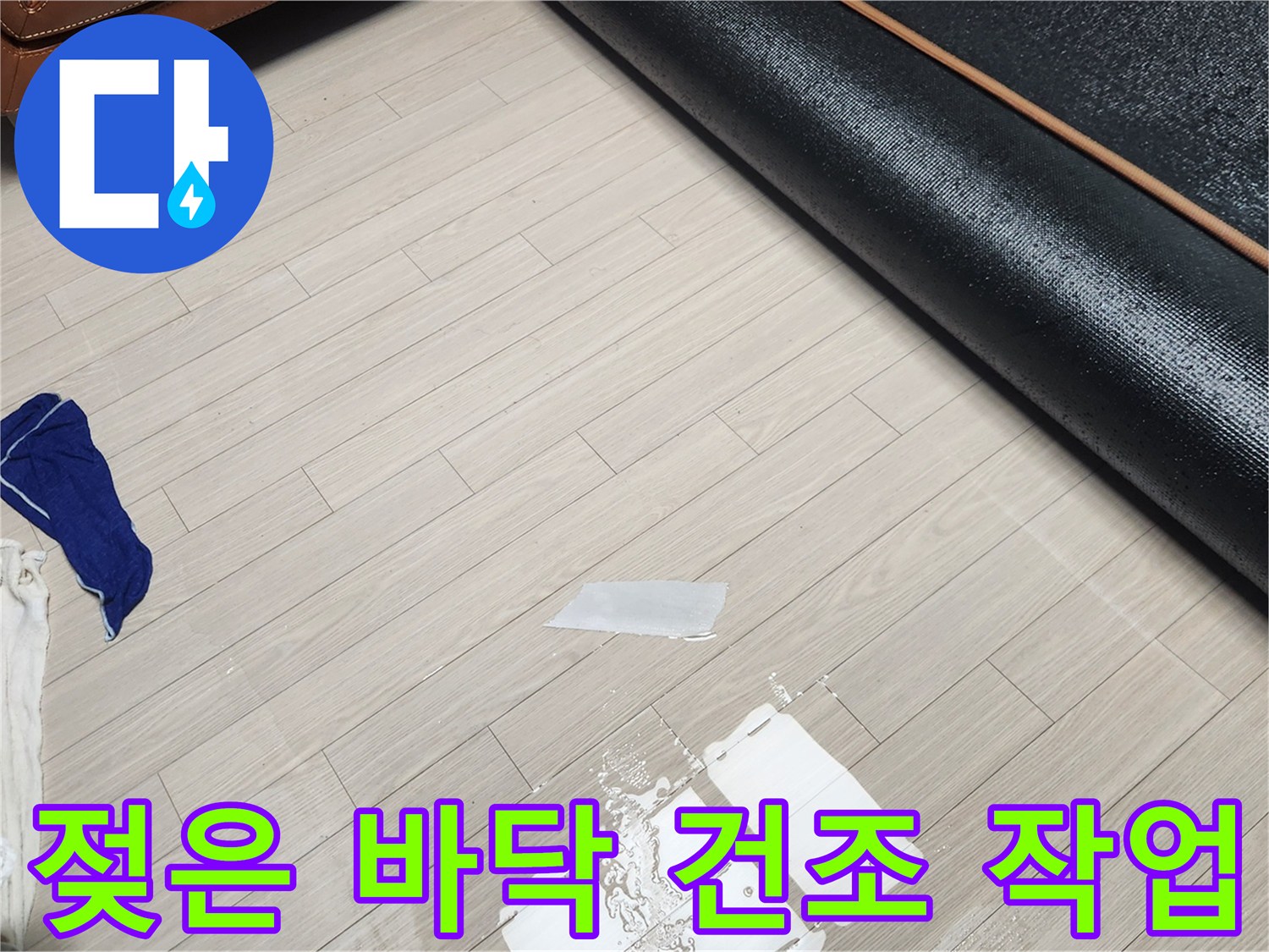 장판 아래 젖어있는 바닥면을 닦아내는 현장