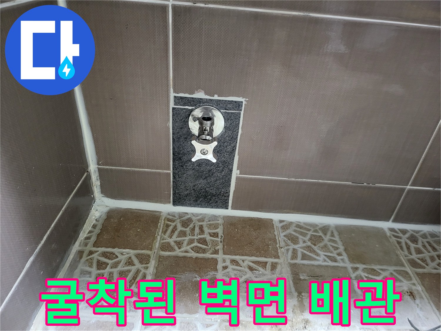 벽면 타일 안쪽의 노출된 수도 연결 부위와 굴착된 자재 상태
