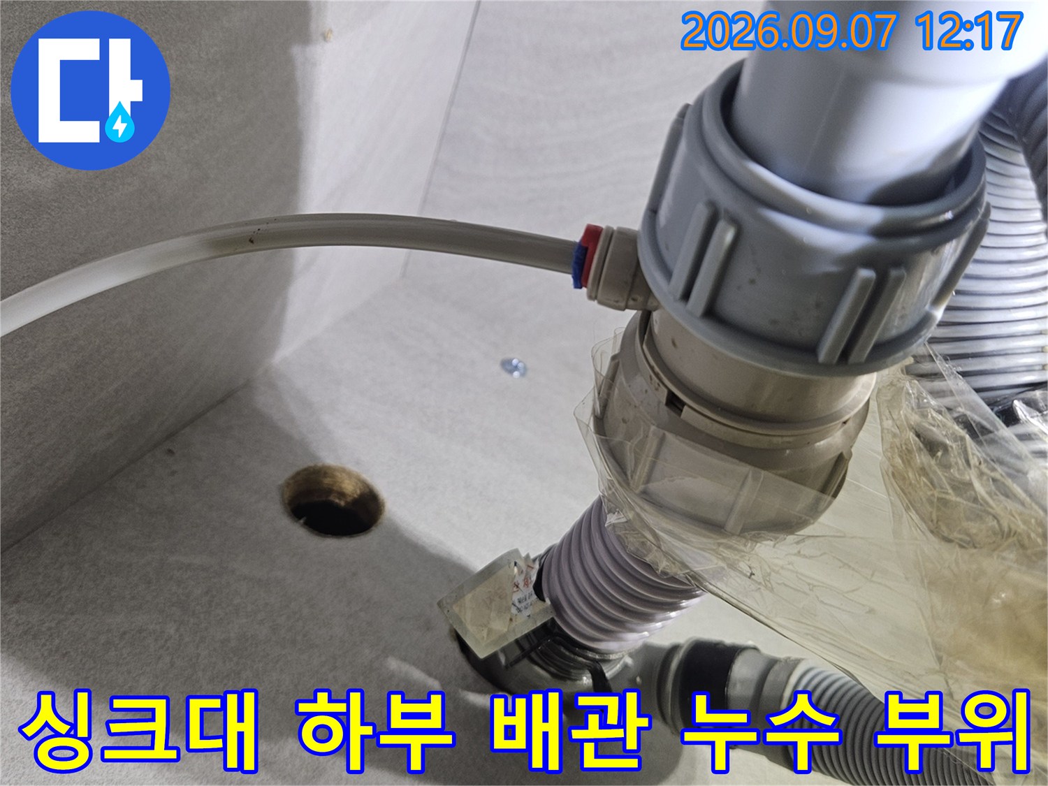 싱크대 아래쪽 훼손된 호스와 연결 부위를 촬영한 사진