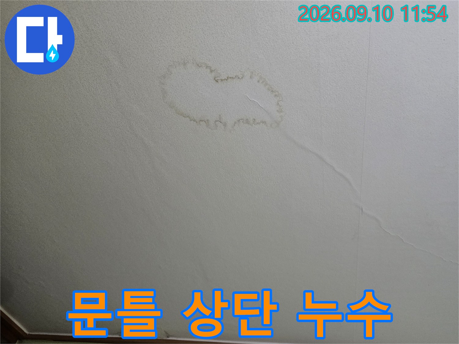 문틀 위쪽 벽지가 젖어 얼룩이 생긴 현장 사진입니다.