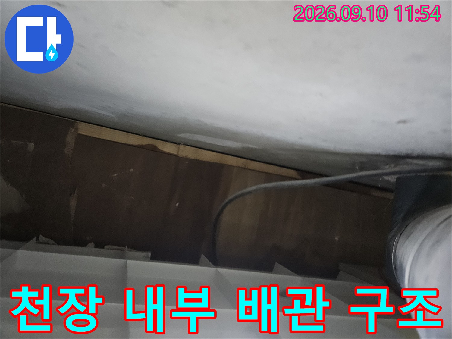천장 안쪽 공간에 설치된 배관과 주변 구조물입니다.
