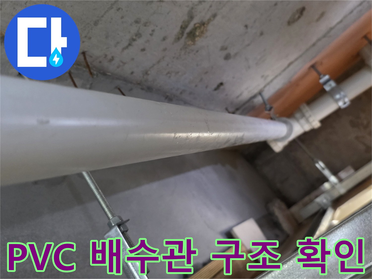 천장 점검구 내부-흰색 배관과 금속 고정 장치