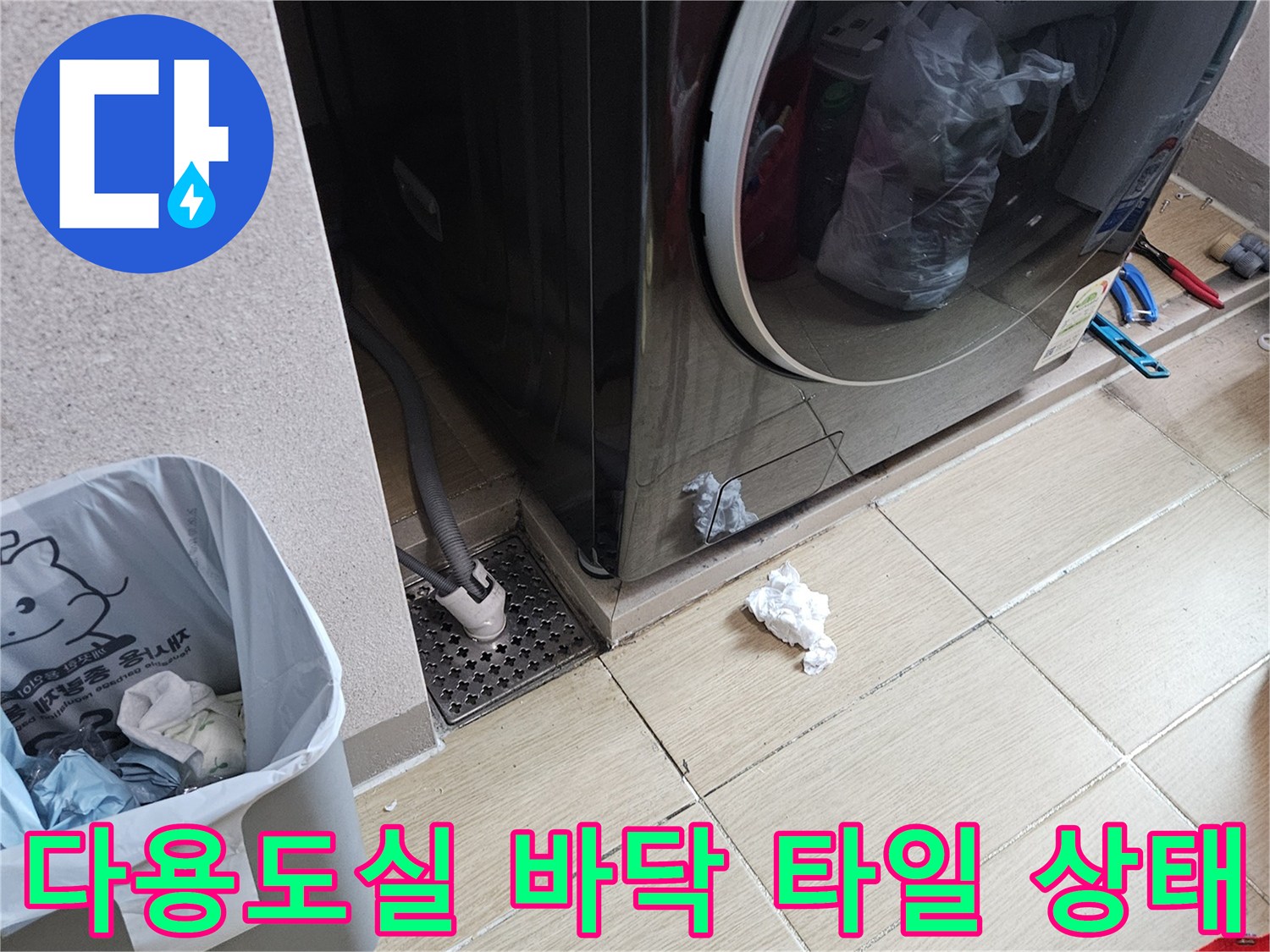 세탁기 옆 배수구 주변의 젖은 타일 모습
