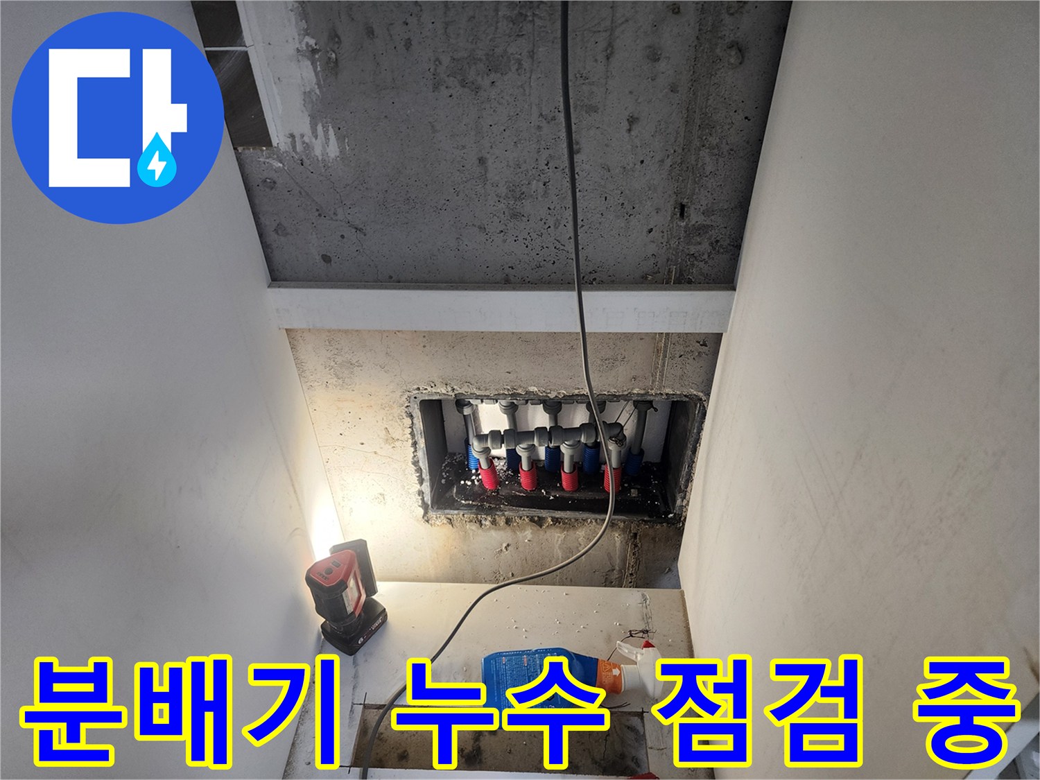 조명 아래 드러난 신발장 하단 배관 분배기 구조