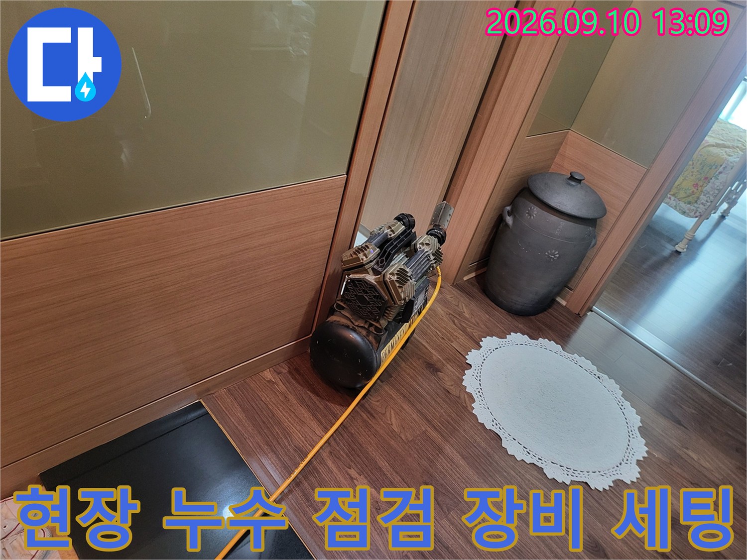 누수 진단을 위해 마루 바닥에 놓여 있는 공압 테스트용 컴프레셔
