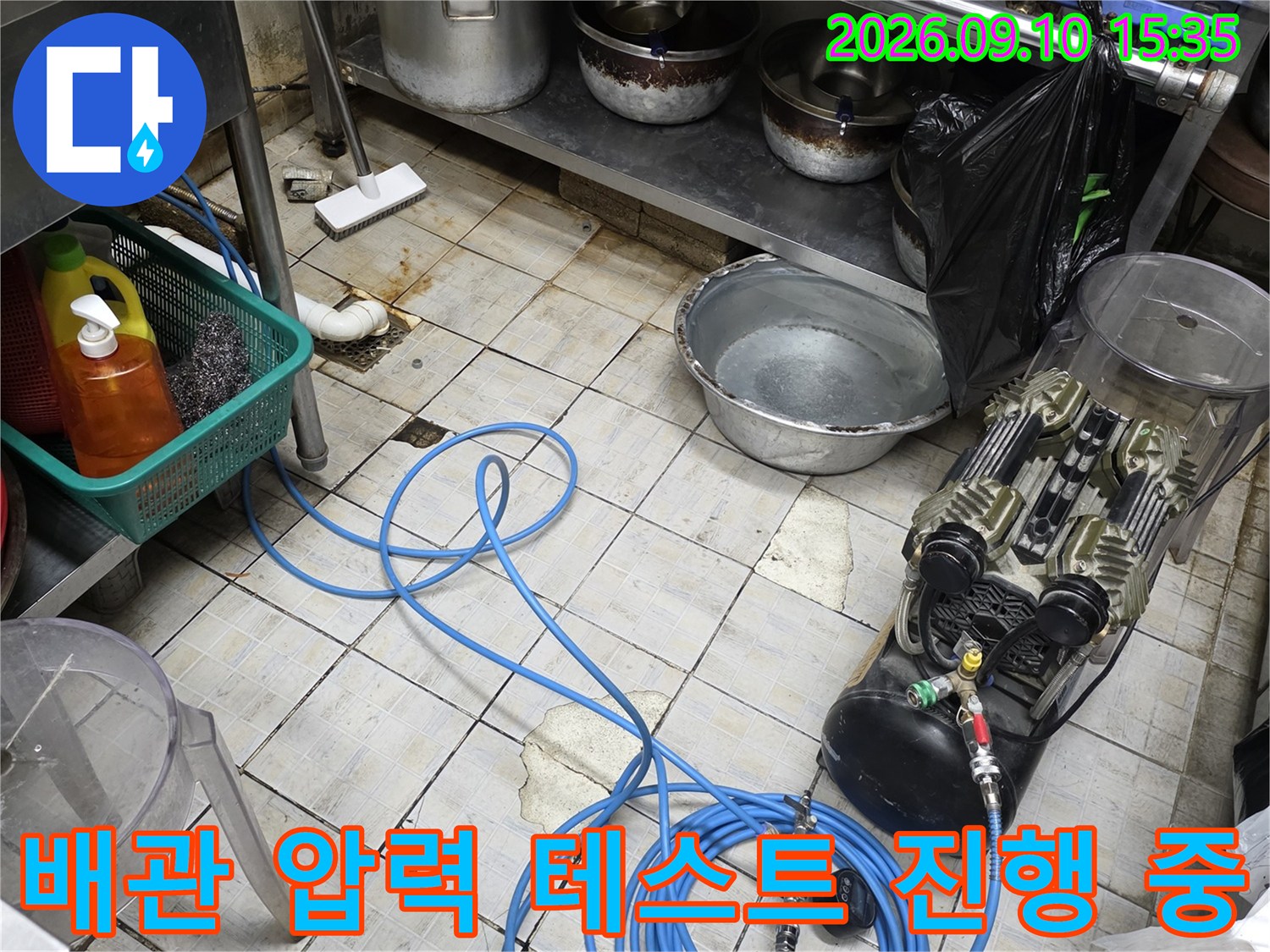 타일 바닥에 놓인 배관 공압 테스트용 게이지와 호스