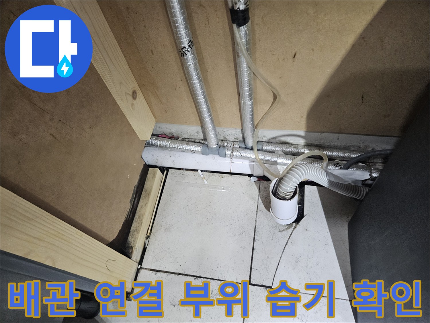 세면대 하단 타일 사이의 물기 맺힌 배관 모습