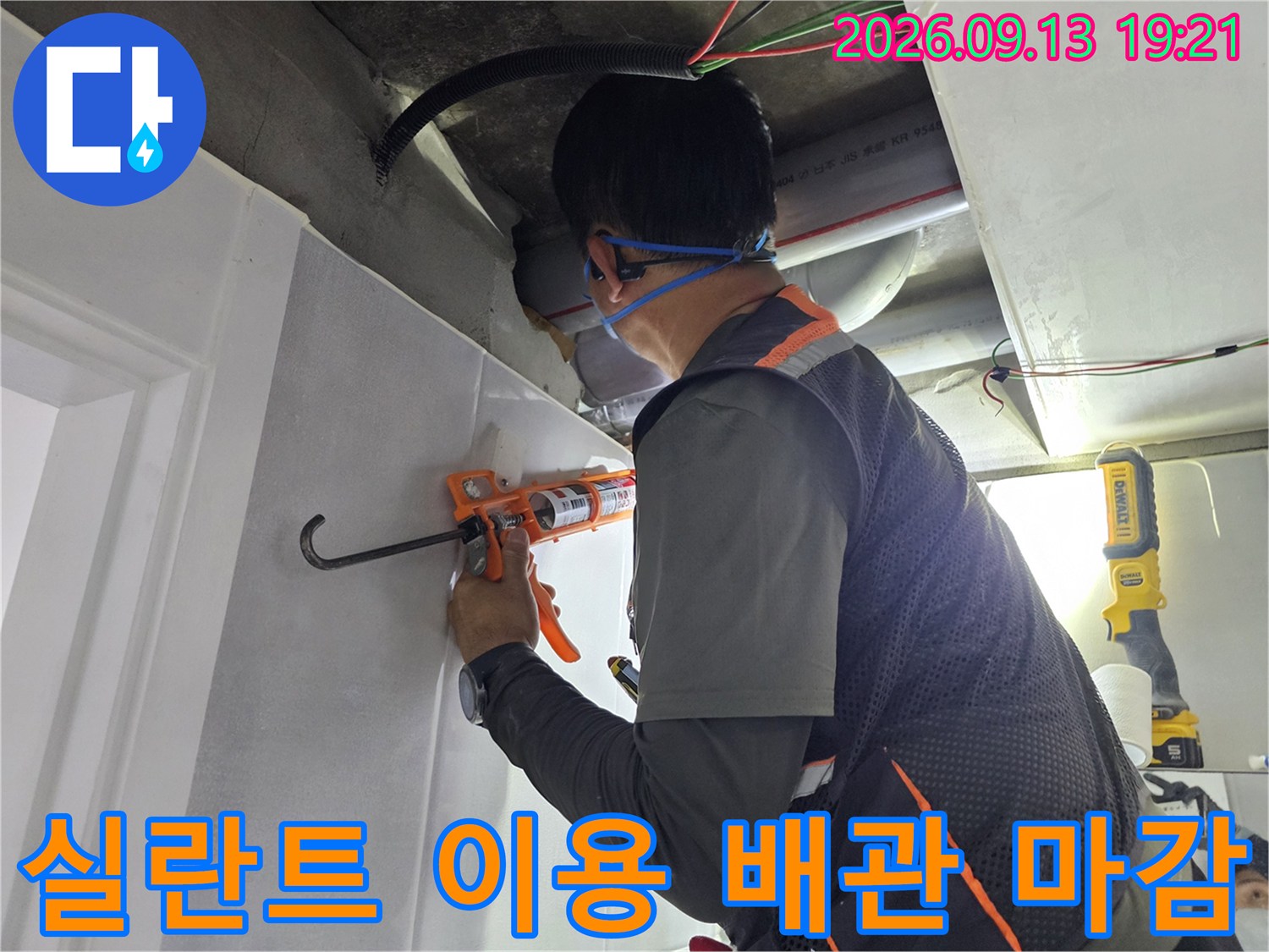 천장 내부의 PVC 파이프 연결 지점에 실란트를 채워 넣는 모습입니다.