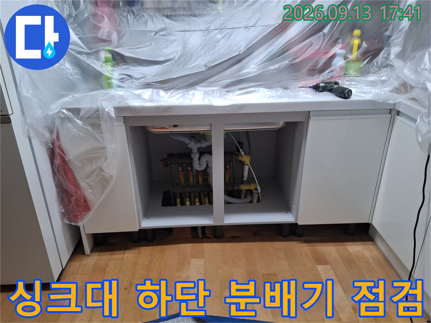 싱크대 하부장 안쪽의 보일러 분배기와 배관 연결 부위