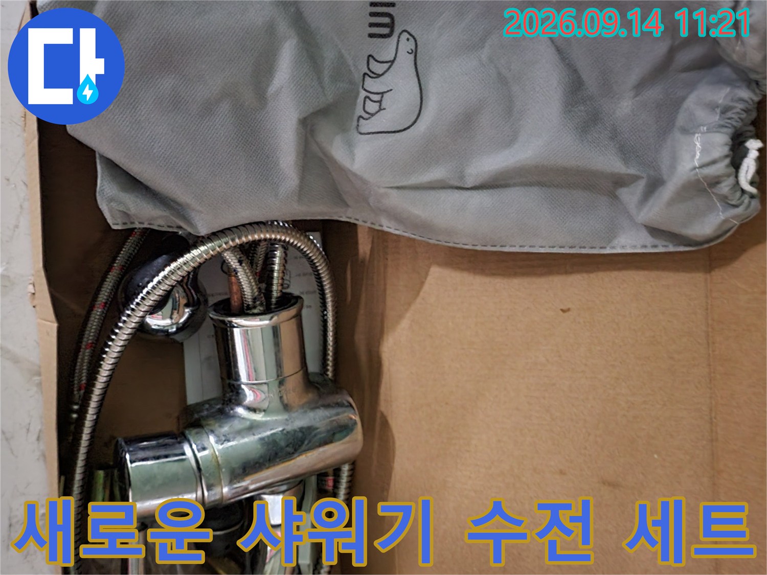 박스에 담긴 샤워기 본체와 샤워 호스 및 파우치