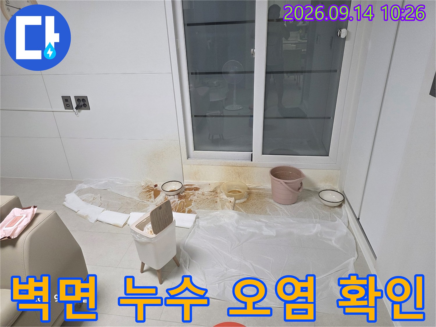 벽면 하단의 갈색 누수 흔적과 바닥 보양 상태를 보여줍니다.