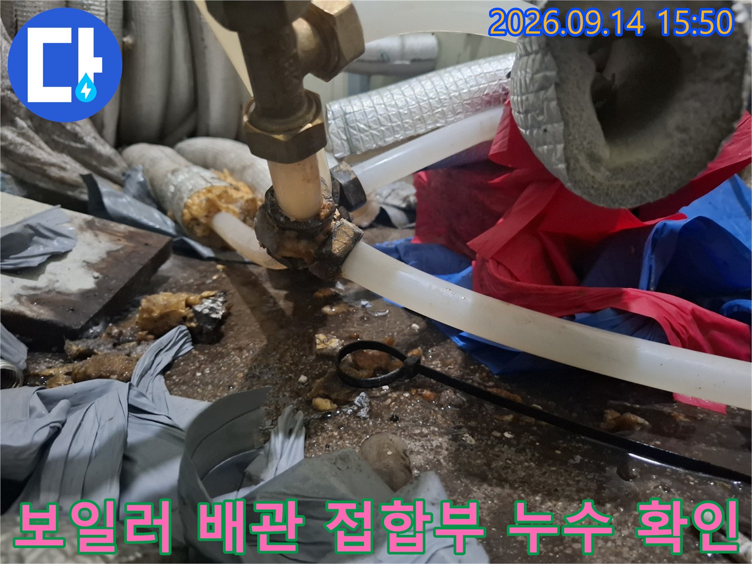 금속 밸브와 투명 호스 연결 부위의 물샘 흔적을 보여주는 사진입니다.