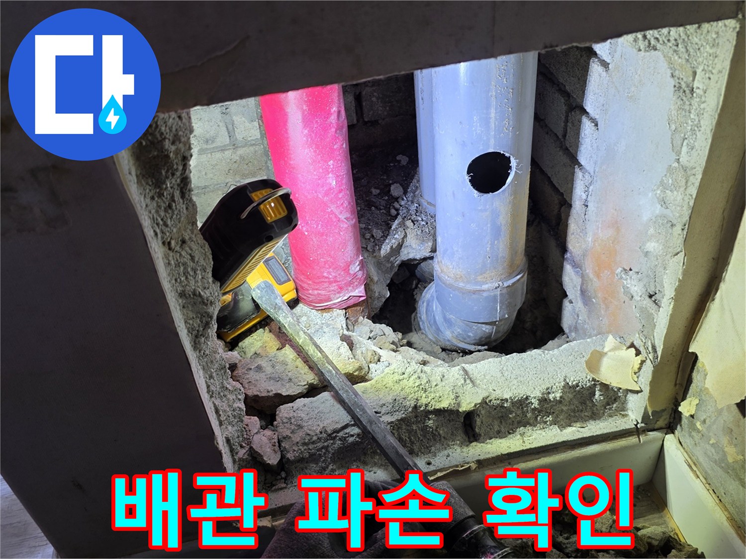 벽을 뚫어 드러난 배관과 작업 도구의 모습