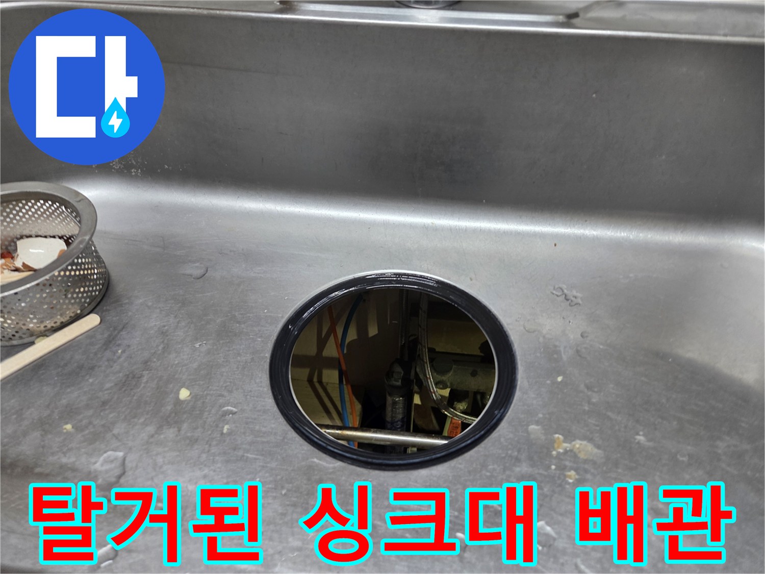 싱크대 배수통을 제거하여 배수구가 노출된 현장 사진입니다.